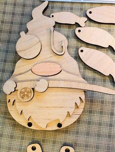 a wooden cutout of a fish and some other wood shapes on a table with buttons