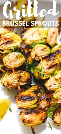 grilled brussel sprouts on a plate with lemon wedges