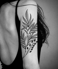 a black and white photo of a woman's arm with a plant tattoo on it