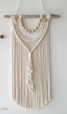 a white wall hanging with beads on it