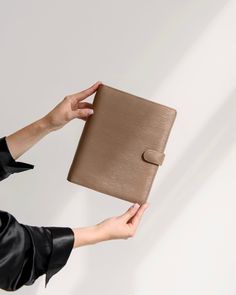 a woman is holding an empty wallet in one hand and her other hand on top of it