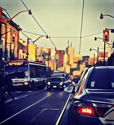 cars and buses on a busy city street with traffic lights in the background at dusk