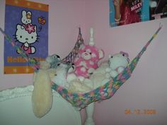 stuffed animals in a hammock with hello kitty pictures on the wall behind them