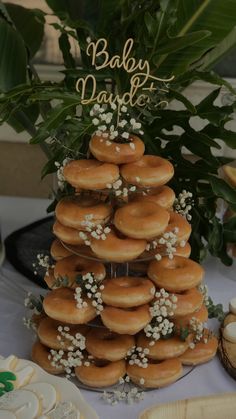 a cake made out of donuts and baby's breath is displayed on a table