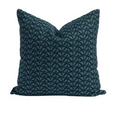 a dark blue pillow with an intricate pattern on the front and back, sitting on a white surface