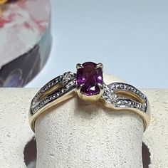 This Pretty Petite Estate Ring Features A Natural 6 X 4mm Oval Rhodolite Garnet, Set With 4 Secure Yellow Gold Prongs. Set On A Criss Cross Open Side Shank There Is A Small Round Natural White Diamond On Each Side Of The Garnet, Both Prong Set With White Gold. The Ring Measures Aprox 5/16" In Width At The Center & Weighs Aprox 2.275 Grams Of Solid (Stamped 14kt Inside Shank) 14kt 2tone Gold. This Pretty Petite Estate Rhodolite & Diamond Ring Is Priced In Our Store At $3699.00. Finger Size 6 3/4 (This Ring Can Be Sized By Your Local Jeweler, At Your Cost, We Do Not Size, Sorry) *All Of Our Vintage And Estate Jewelry Is Sold As Is And Has Been Checked For Security On Gems By Ceres, And Or Estate Ring, Estate Rings, Rhodolite Garnet, Womens Jewelry Rings, Estate Jewelry, Rings Statement, White Diamond, Red Gold, Prong Setting