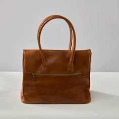 The Antonella Tote Bag is a office-appropriate carryall and that 'something sleek' for your 9-to-5 routine. The stunning cognac leather will develop an authentic patina over time, making it even more luxurious looking. Comes with Hektor + Helena's Lifetime warranty and guarantee. Made of Italian vegetable tanned leather, our bags are all handmade by master craftsmen who have been perfecting their skills for generations. The result is a striking blend of rich earth-toned colors, providing a glowi Cognac Briefcase With Leather Handles For Office, Cognac Leather Briefcase For Office, Leather-lined Satchel Bag For Work, Timeless Cognac Satchel With Leather Handles, Leather Lined Satchel Bag For Work, Leather Lined Tote Briefcase For Work, Leather Lined Double Handle Briefcase For Work, Double Handle Leather Lined Briefcase For Work, Cognac Briefcase With Leather Handles