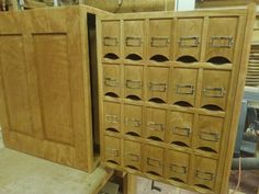 a wooden cabinet with many drawers on it's sides in a shop area next to other items