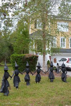 halloween decorations in the front yard of a house with a car parked on the driveway