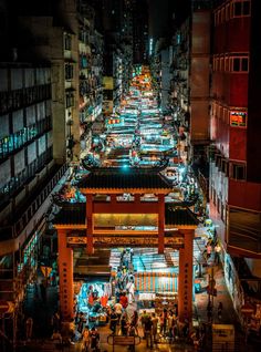 an aerial view of a city street at night with lots of people walking around it