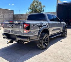 the rear end of a gray truck parked in a parking lot