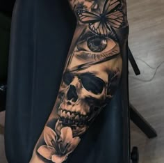 a person with a skull and butterfly tattoo on their arm