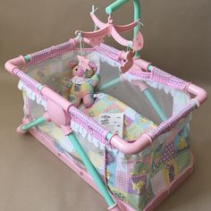 a pink baby crib with a teddy bear in it