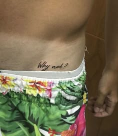 a man with a tattoo on his stomach that says why not? in hawaiian print