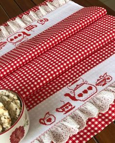 a red and white table cloth with a bowl of popcorn next to it on a wooden table