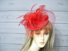 "Red fascinator with rosette center and matching biot feathers. You can wear this two ways, the veil in the front or turn it around for a different look. This is attached to a headband but I will include a clip so you can decide which you like best. Very light weight and easy to wear. Wear on either side of your head. Budget friendly. Love that! Size is about 11\" wide by 8\" tall. See other colors in my shop. Perfect for many events from weddings to Kentucky Derby.  I ship priority mail, it's more expensive but more reliable. Check out my other items in my shop https://www.etsy.com/shop/MsPurdy I ship many times a week. All sales are final. no exchanges or refunds. I accept paypal, credit cards and etsy gift cards. More items in my Etsy shop: https://www.etsy.com/shop/MsPurdy Internationa Garden Party Tea, Red Fascinator, Kentucky Derby Fascinator, Derby Fascinator, Ky Derby, Hat Wedding, Easter Hats, Tea Party Hats, Riding Hats