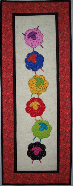 a quilted wall hanging with flowers on it