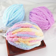 three different colored towels sitting on top of a wooden tray next to a keychain