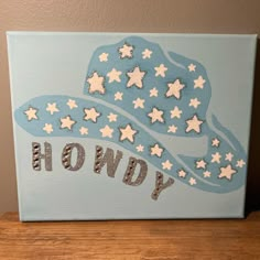 a blue and white painting with stars on it that says, howdy written in silver glitters