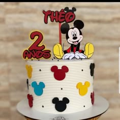 a mickey mouse birthday cake with the number two on it's top and decorations