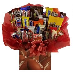 a football themed gift basket filled with candy and candies, wrapped in red ribbon