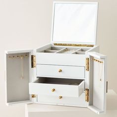 an open white jewelry box sitting on top of a table