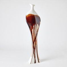 a white and brown vase sitting on top of a table