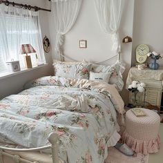 a bedroom with white walls and floral bedding on the floor, along with an old fashioned dresser