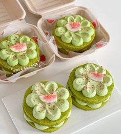 four green cupcakes with white frosting and sprinkles on them