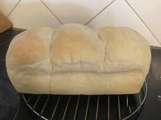 a loaf of bread sitting on top of an oven rack in front of a wall