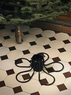 a black and white tile floor with a potted tree in the middle on it