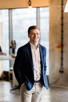 a man standing in an office smiling for the camera