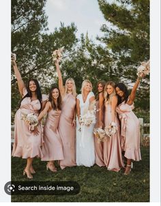 a group of women standing next to each other on top of a lush green field