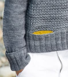 a person wearing a sweater with a yellow patch on it