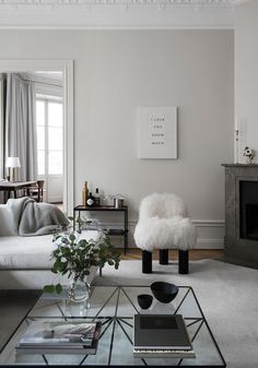 a living room filled with furniture and a fire place next to a white couch in front of a fireplace