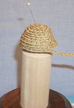 a white vase sitting on top of a wooden stand next to a blue cloth covered wall