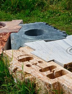 several pieces of wood that have been cut into shapes and placed on the ground with grass around them