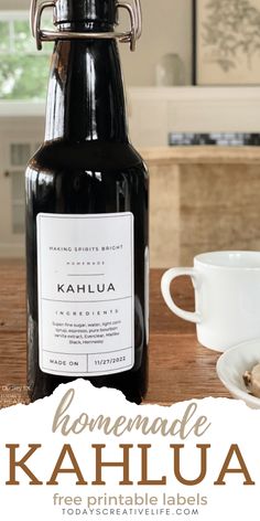 a bottle of kahlua sitting on top of a table next to a cup and saucer