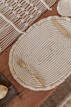 a table topped with plates and utensils on top of a wooden table covered in jute