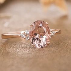 an oval pink diamond ring with three diamonds around it