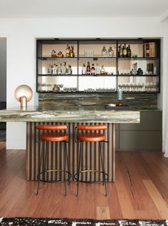 a bar with three stools in front of it