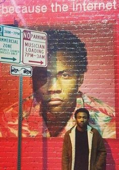 a man standing in front of a brick wall with a poster on it that says no parking