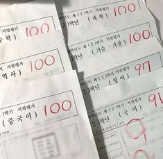 several pieces of white paper with red writing on them and some type of numbers written in korean