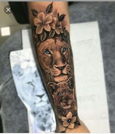 a lion and cub tattoo on the arm