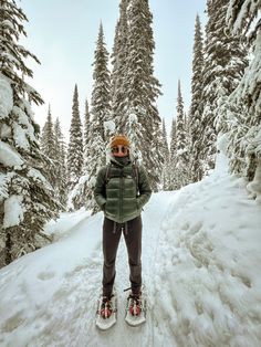 a person standing on skis in the snow with trees behind them and snow covered ground