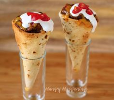 two burritos with toppings in glass cups