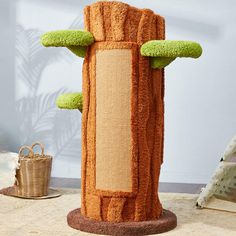 a cat scratching tower made out of yarn with green trimmings on the top