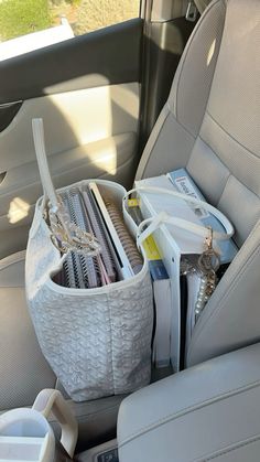 a car seat filled with lots of items in it's holder and storage compartment