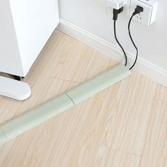 an electrical outlet plugged in to a wall next to a floor with wood floors