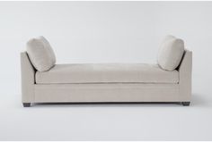 a white couch with two pillows on it's back and the seat upholstered